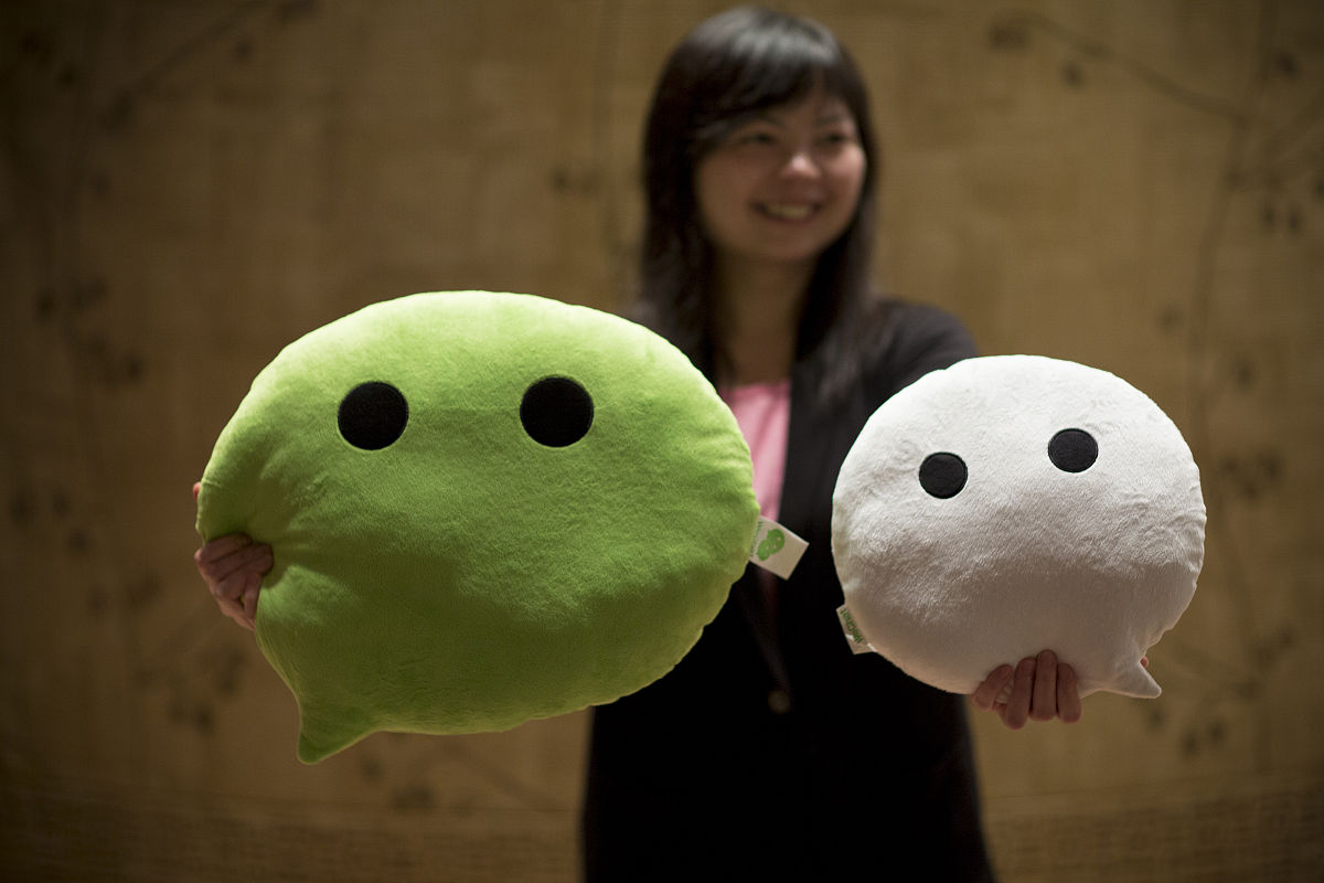 a woman poses for a photograph with wechat pillows promoting ten