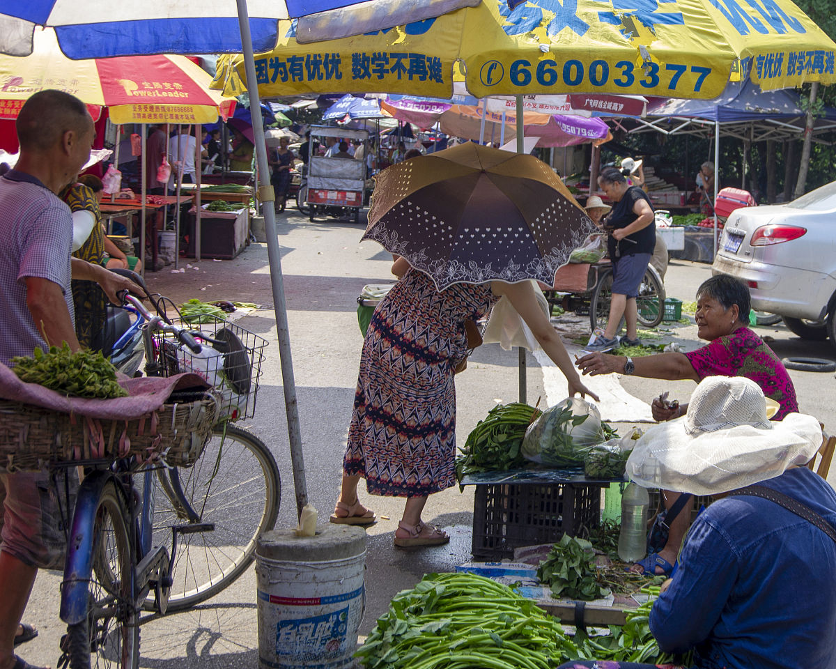 一个用白色帆布搭成的路边小摊上面有个红色的风扇小摊的主人不见踪影请用以上文字编写一段有诗意文案