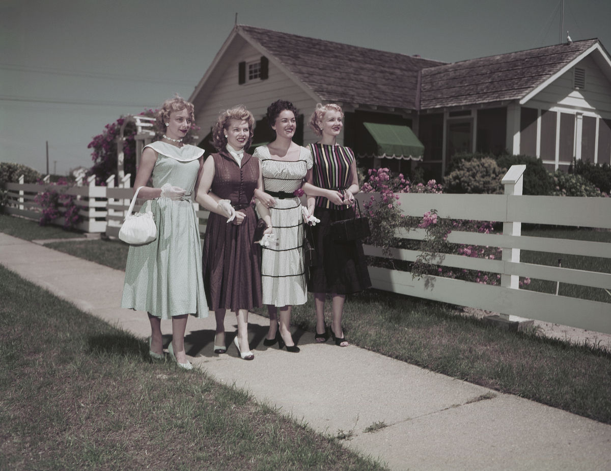 beautiful women walking on road in front of house