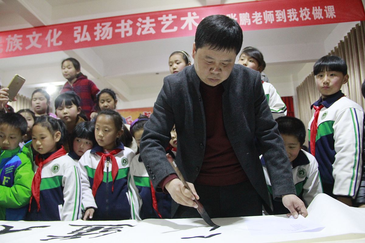 2016年3月25日,河南省内黄县第三实验小学,书法名家在教孩子们学写毛