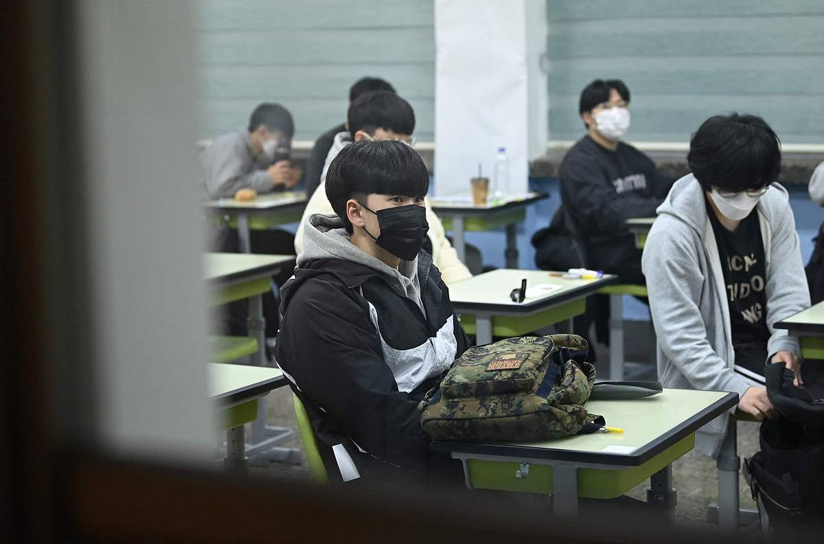 当地时间2021年11月18日,韩国首尔,考生们相继进入考场.韩国2022学年