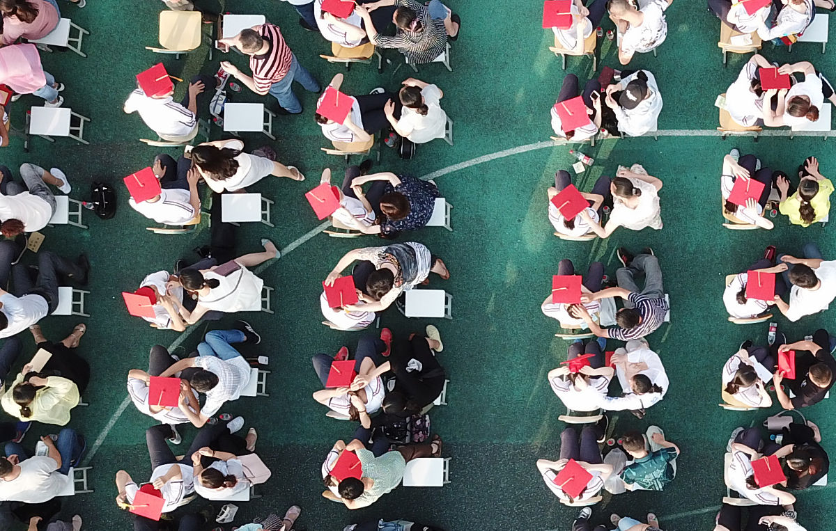 2018年6月15日,在江苏扬州第一中学成人礼上,家长为孩子佩戴"成人帽".