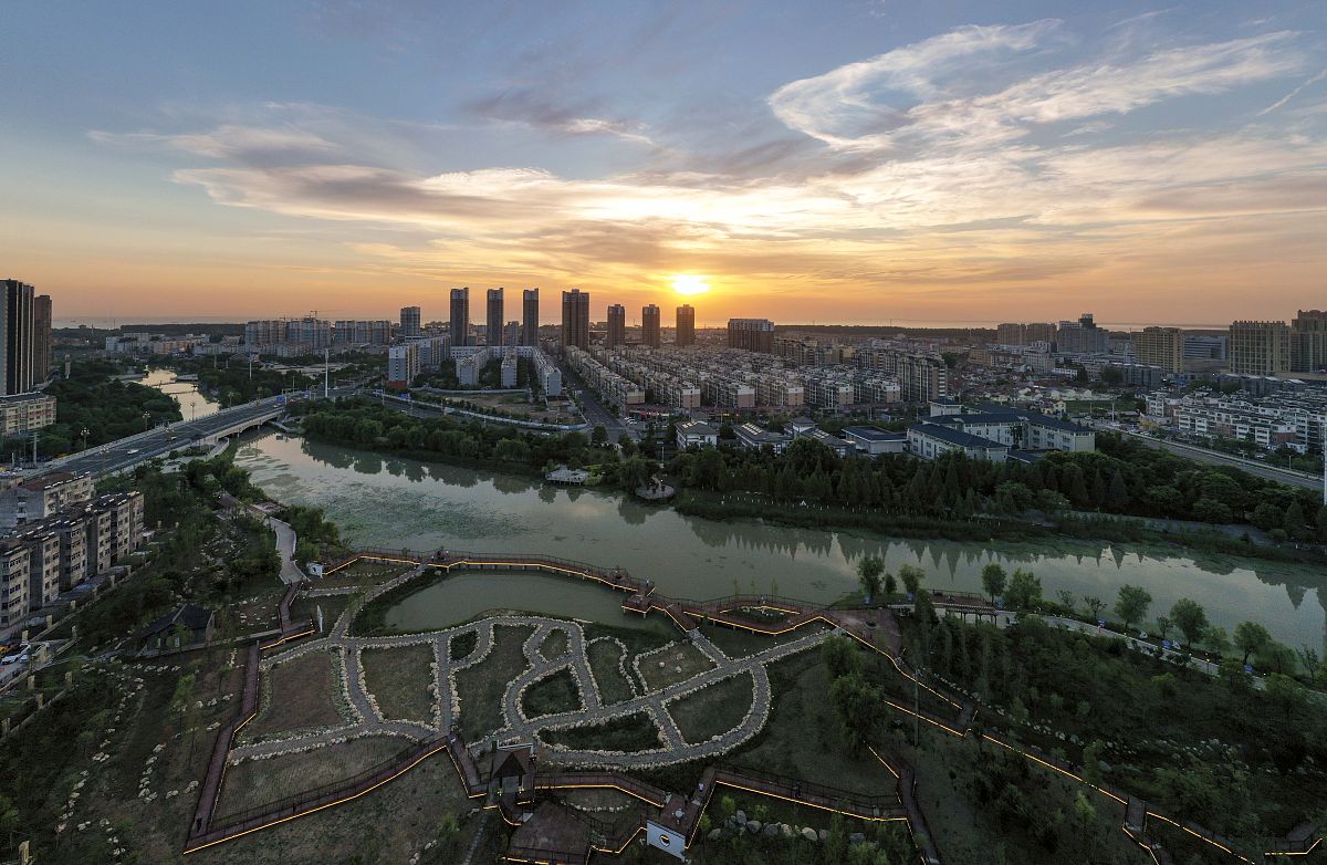 2021年6月7日傍晚,江苏淮安,夕阳映照下的洪泽区砚临河生态滨水公园.