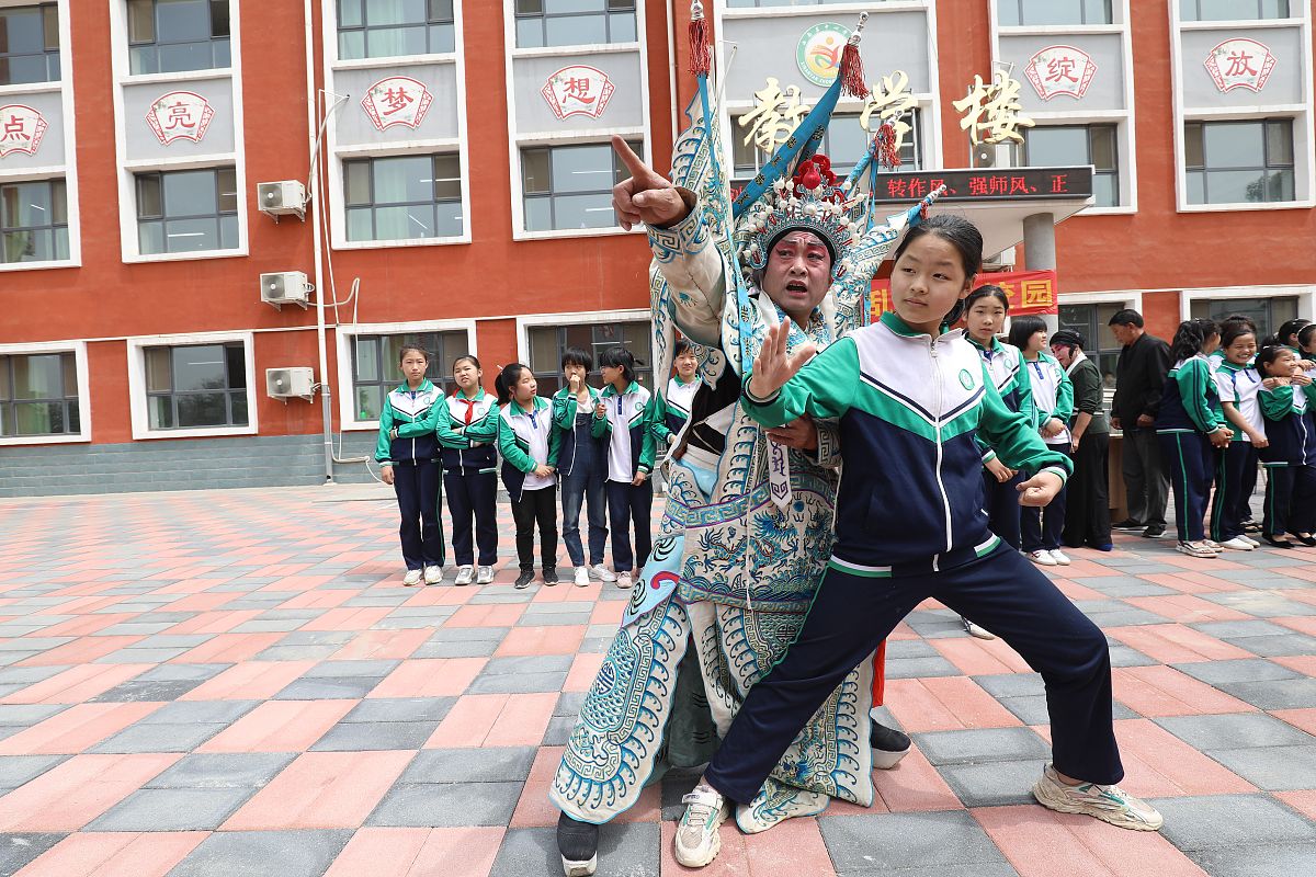 2021年5月26日,在石家庄市高邑县南岩中心小学,演员正在指导一名学生