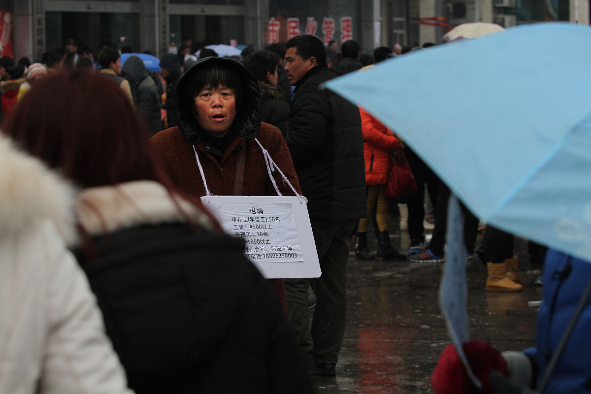   2014年2月19日,众多举着招工牌子的家纺企业招工人员聚集在江苏南通