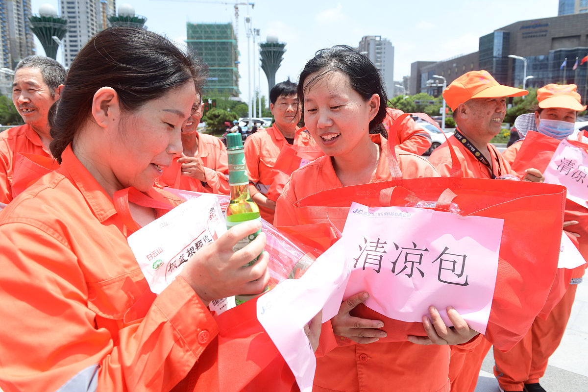 2021年7月13日,安徽阜阳,环卫工人们高兴地领到单位统一发放的高温"清