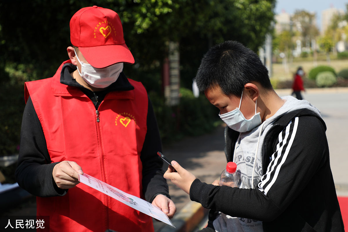 2020年2月14日,云南红河蒙自市,志愿者在艺海社区开展宣传"云南抗疫情