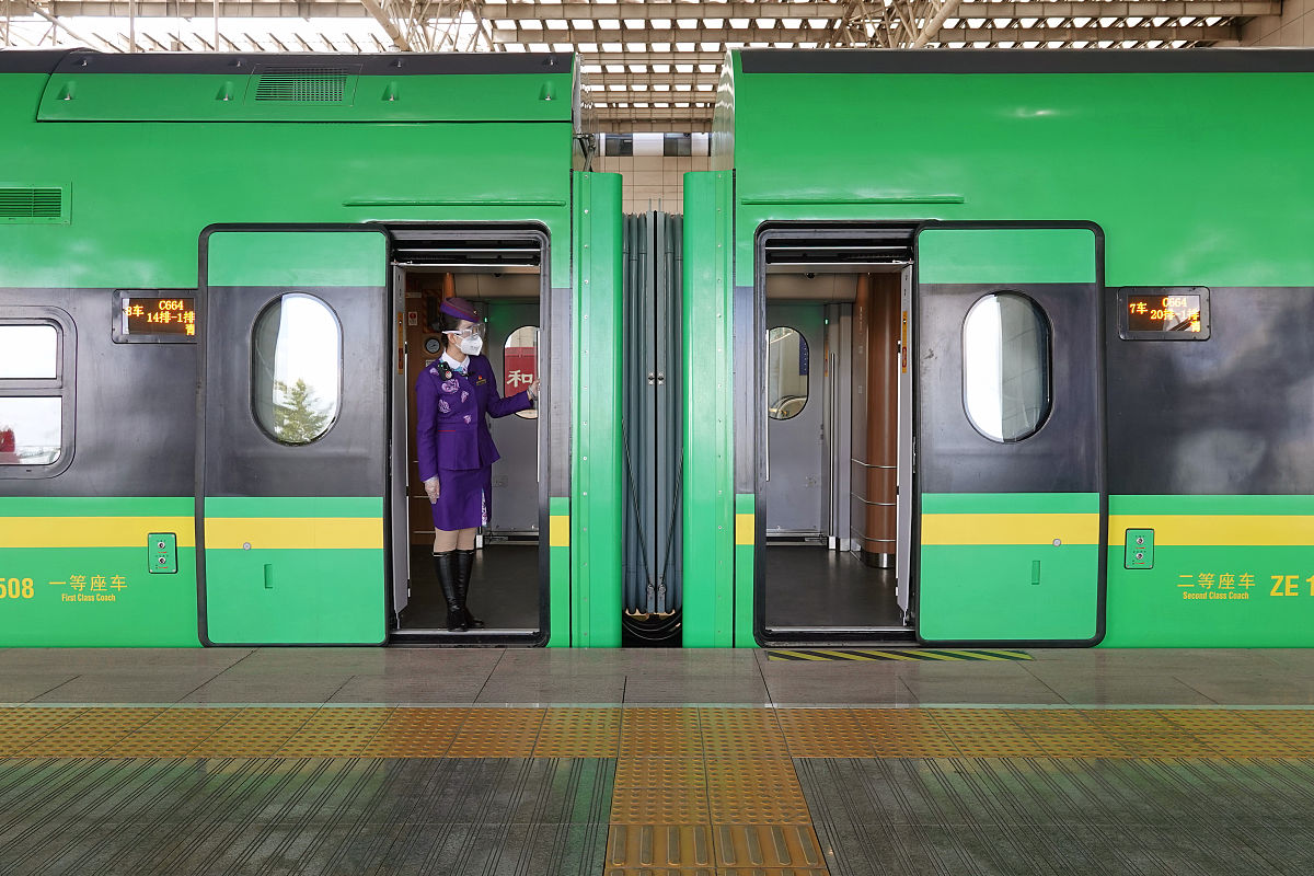 2021年11月12日,在山东烟台火车站,c664次列车的乘务员在迎接旅客.