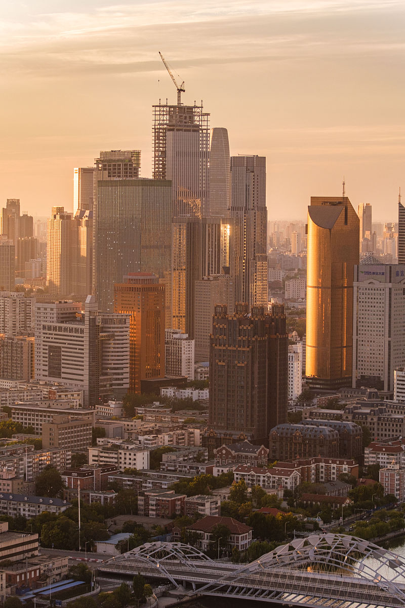 2021年10月10日,阴雨多日的天津迎来夕阳晚霞,日落时分,整个城市都变