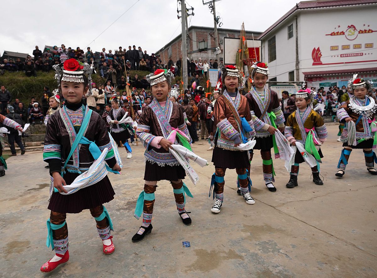 2022年1月3日,在广西融水苗族自治县杆洞乡锦洞苗寨,几名苗妹在跳苗舞