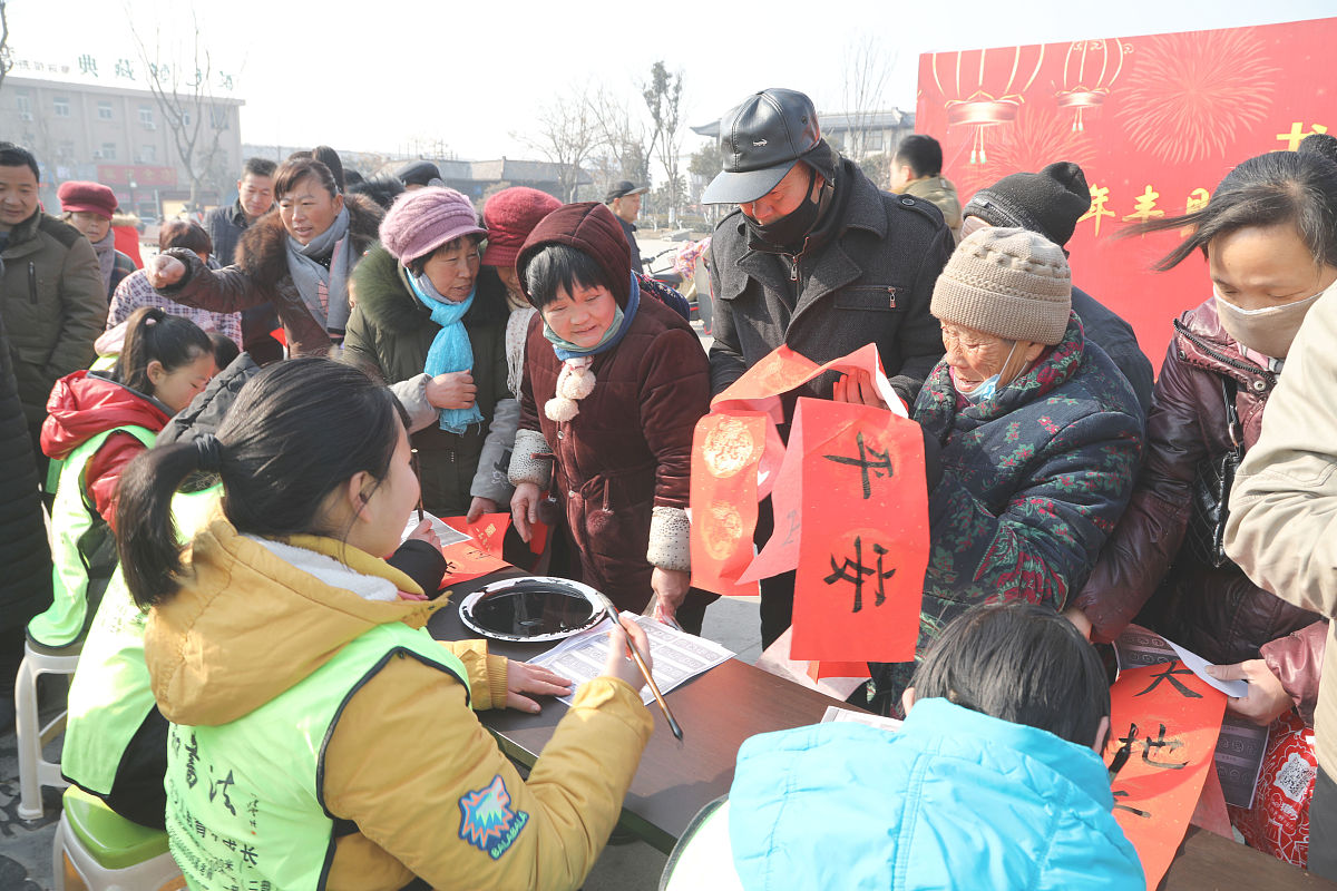 2018年2月7日,江苏徐州,青少年"书法家"为市民书写春联.