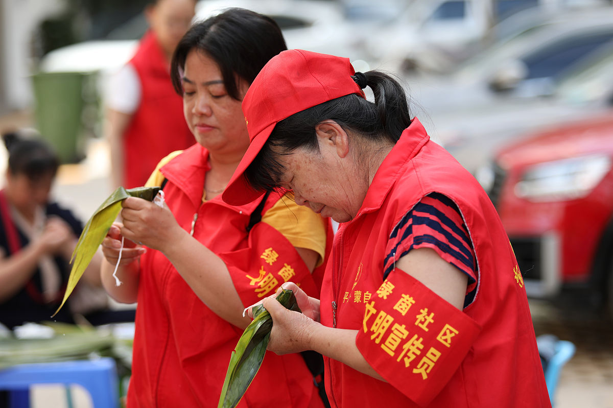 2020年6月23日,社区工作人员和居民在云南省红河州蒙自市绿茵社区包粽