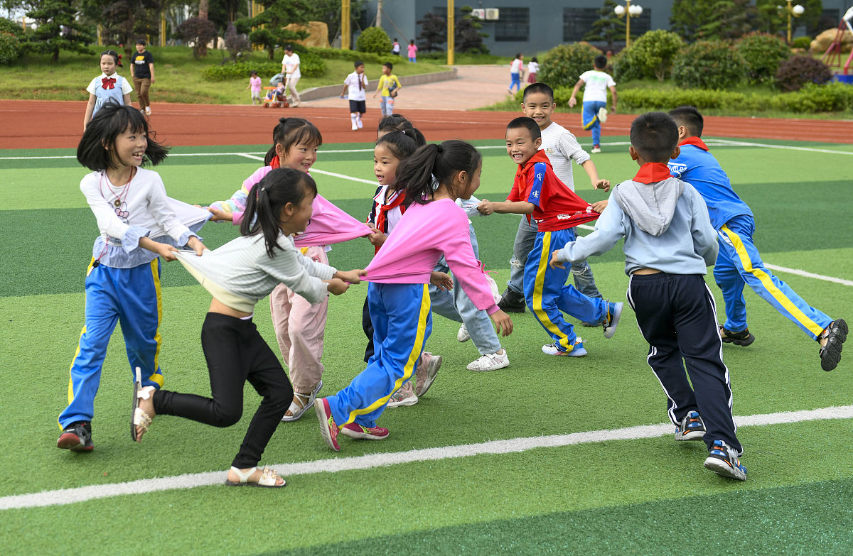 2021年5月31日,在湖南省道县第二小学,学生在玩"老鹰捉小鸡"游戏.