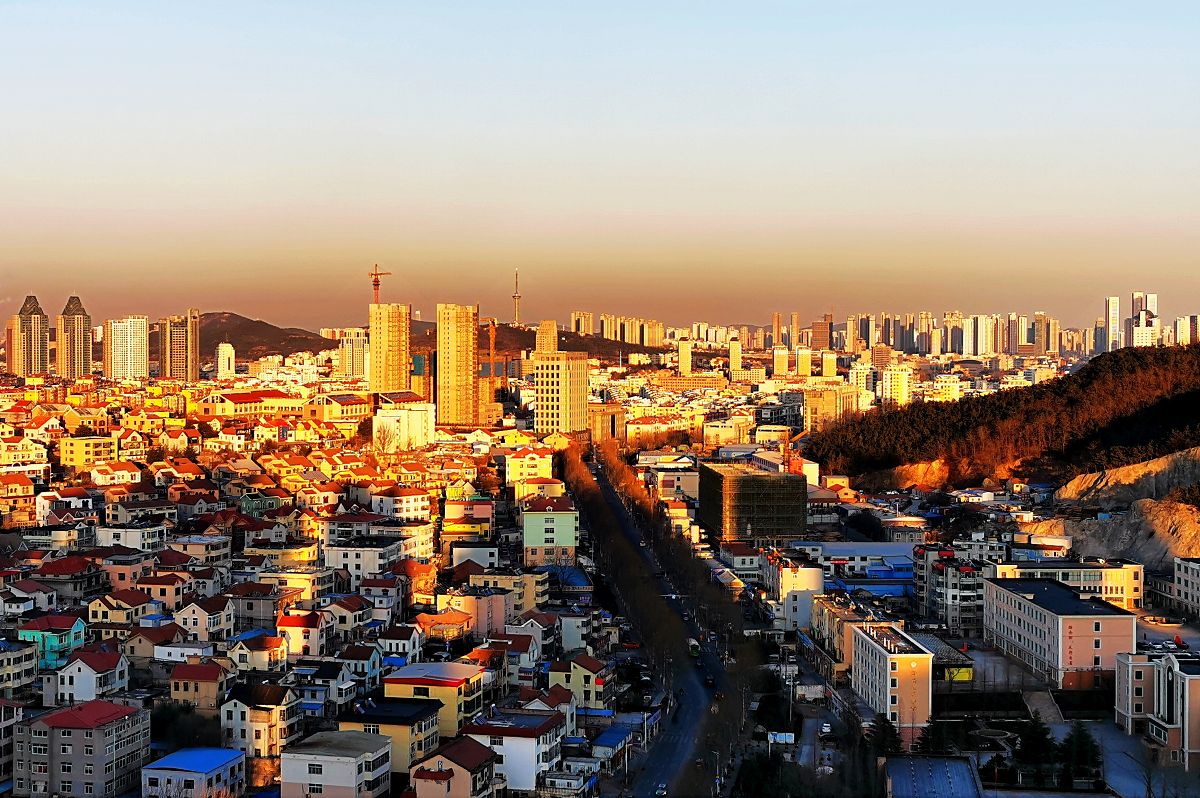 2021年12月27日,山东青岛,夕阳余晖呈现出一片暖金色,将西海岸城区装