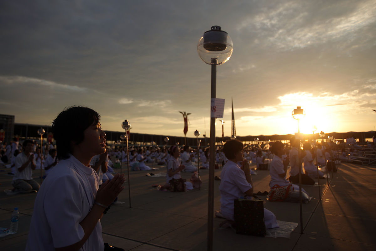 2012年3月7日,泰国巴吞他尼府,数千名僧侣坐在灯烛旁诵经,庆祝万佛节.