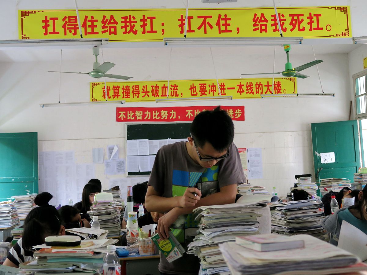 优化下面文章1998年龙江省尚北一中十七号考场。齐磊怔怔地看着窗外视线穿过葱翠的杨树林定格在校外一间门脸房上——《潮流音像店》。隐约有一道歌声穿透力极强灌进耳膜。仔细辨认是张学友的《一千个伤心的理由》真潮流啊！僵硬着脖子收回目光身前一张课桌映入眼帘。好吧这课桌就更厉害了纯实木无拼接贴个牌子放在高档家具城光桌板就值个千八百的。就是有点旧都掉漆了不知多少位神人落下的数学公式和歌词、名言摞在一块儿。其间