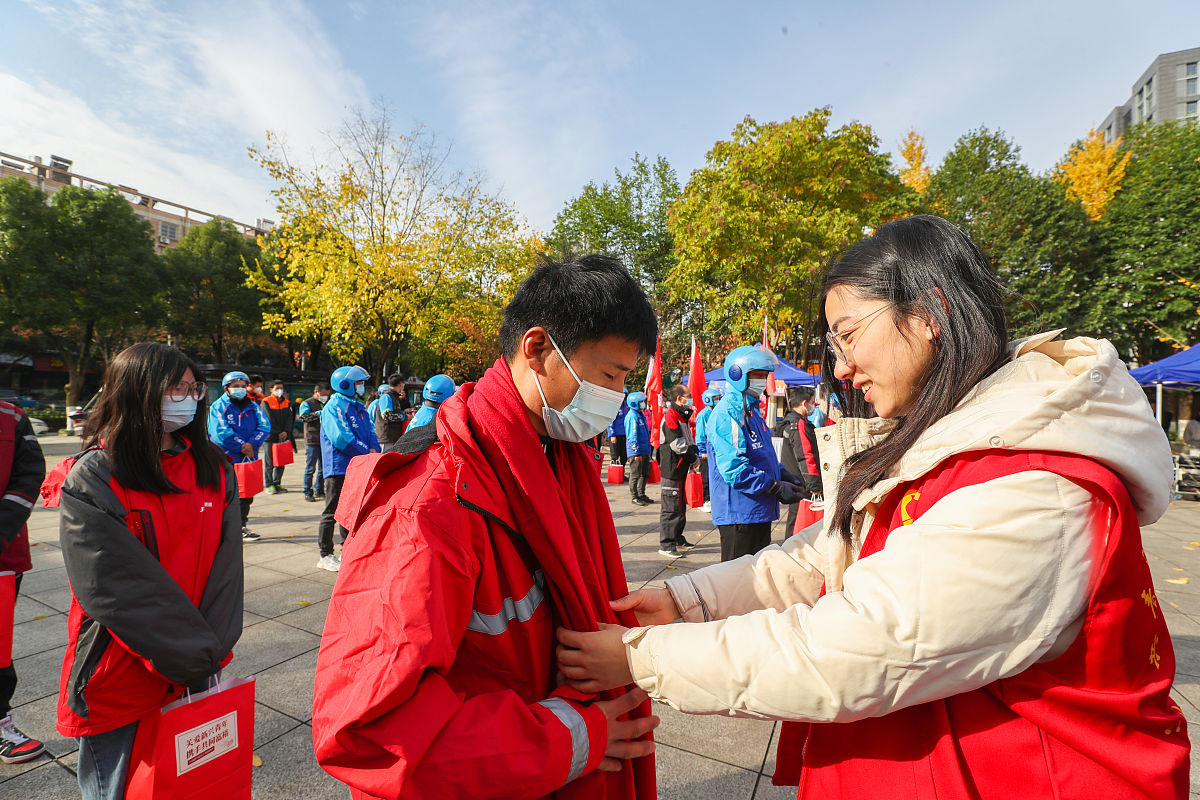 2021年11月22日,在浙江省湖州市德清县武康街道,"德小青"志愿者为快递