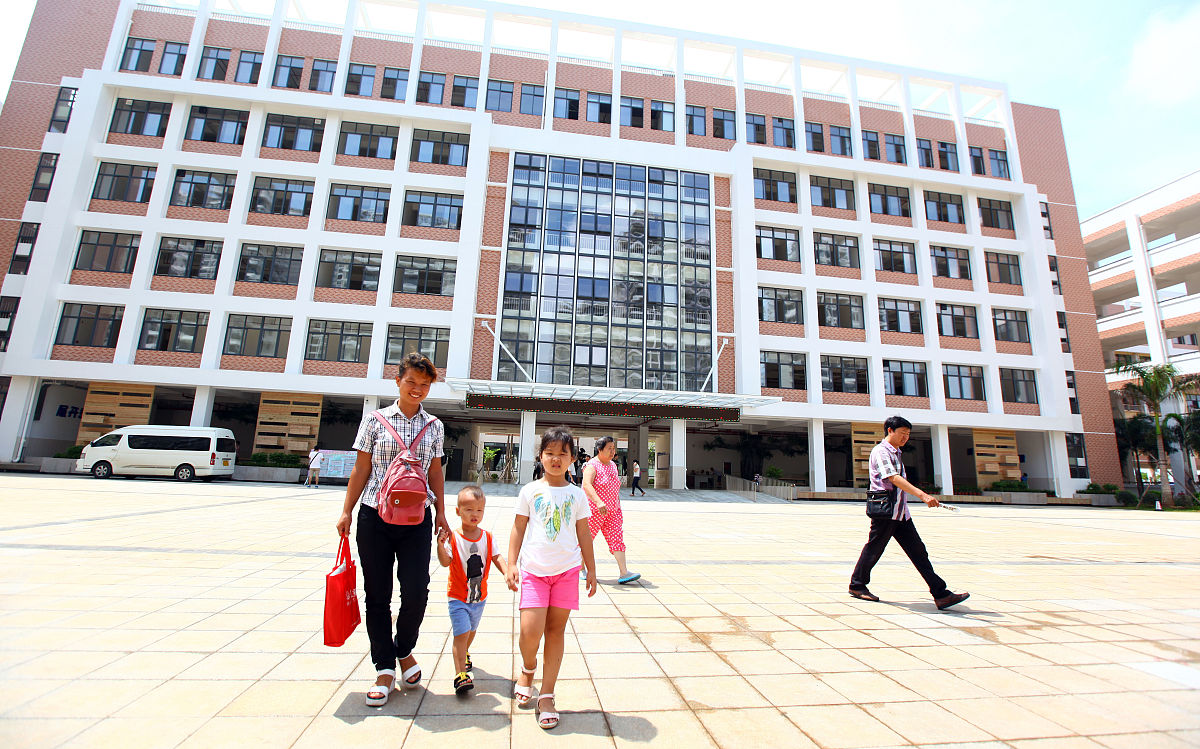 2016年8月30日上午,海口市五源河学校小学一年级新生领取新课本后高兴