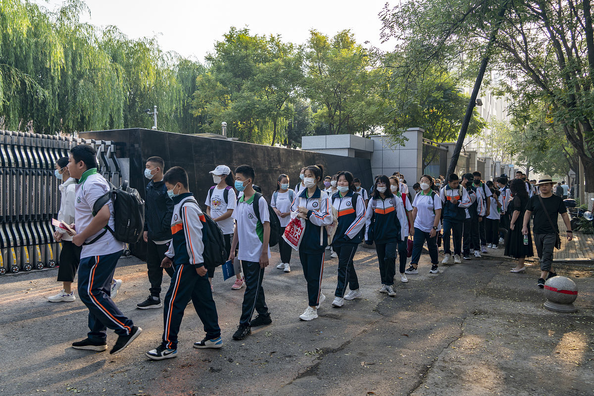2021年9月1日,辽宁锦州十八中学的学生们佩戴口罩,在校门外自觉排队,