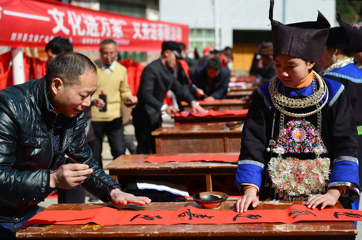 2018年2月5日,贵州黔东南,在剑河县观<strong>么</strong>镇新合村苗寨,书法家在为苗族