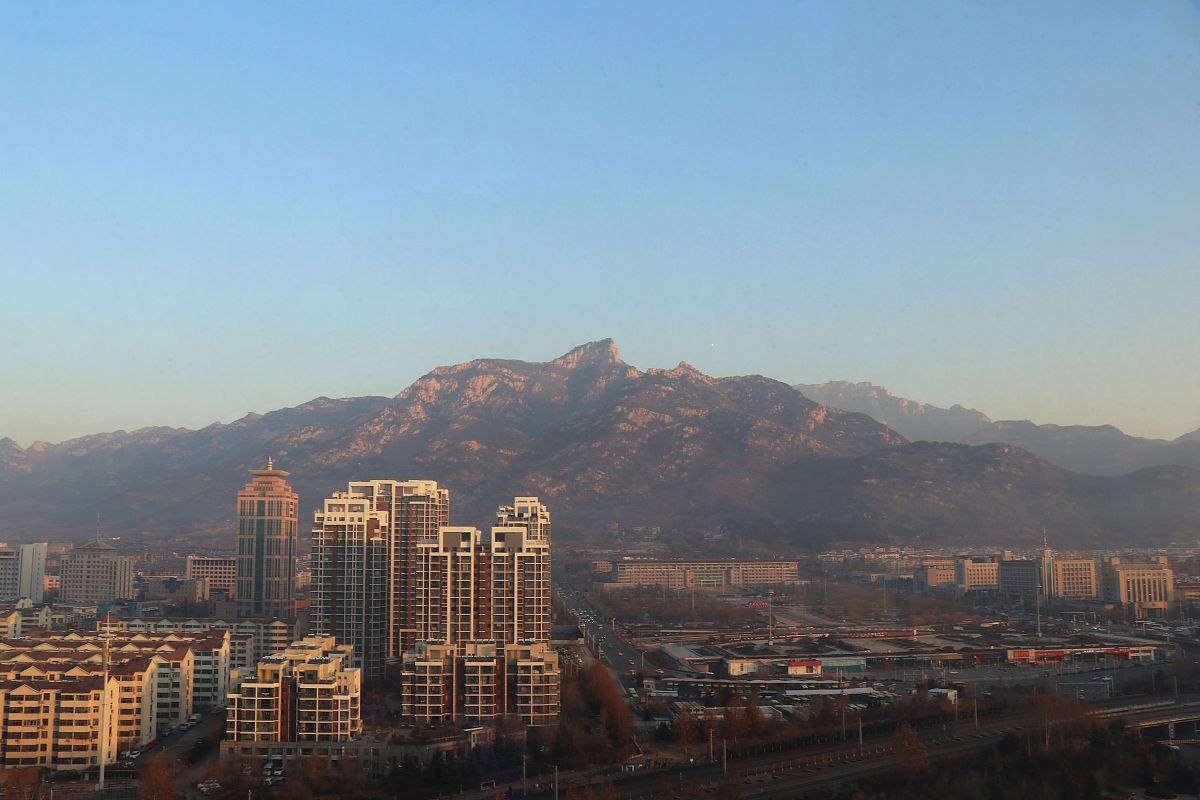 2020年12月16日,山东泰安.冬季的泰山与城市,在朝阳照射下,成天然的美