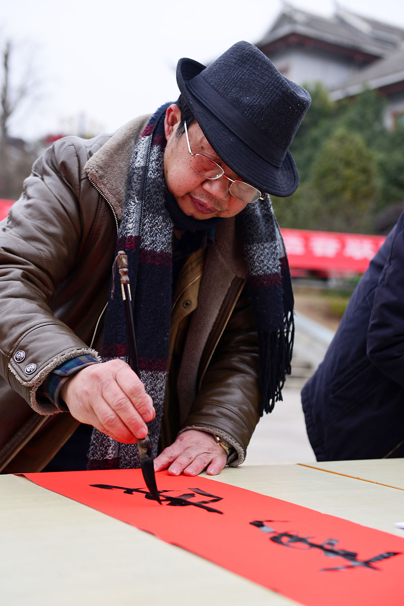 2018年2月3日,在贵州省剑河县,书法爱好者在为群众书写春联.