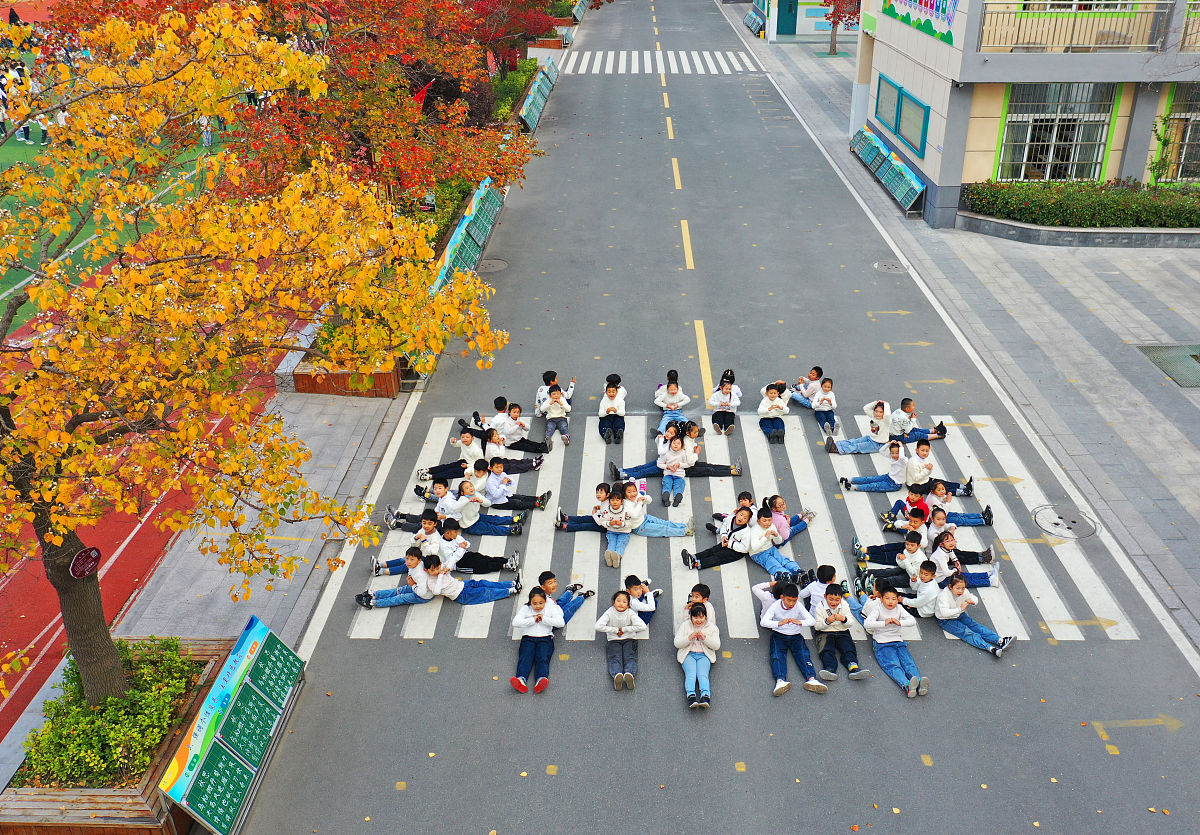 2021年11月2日,江苏省徐州市睢宁县第二小学的学生在乌桕树下拍照,留