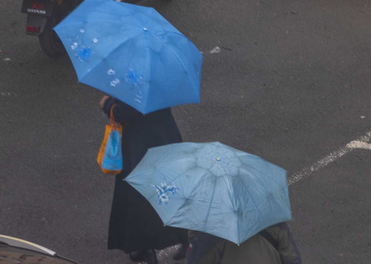 2026年4月10日,吉林市船营区,春雨中家长接孩子放学.