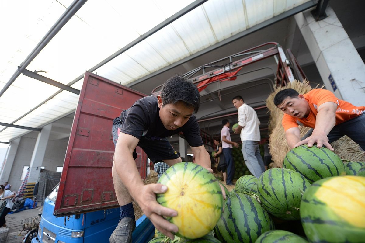 2012年06月14日,江苏省扬州市,一水果批发市场里,市民和瓜商正在选购