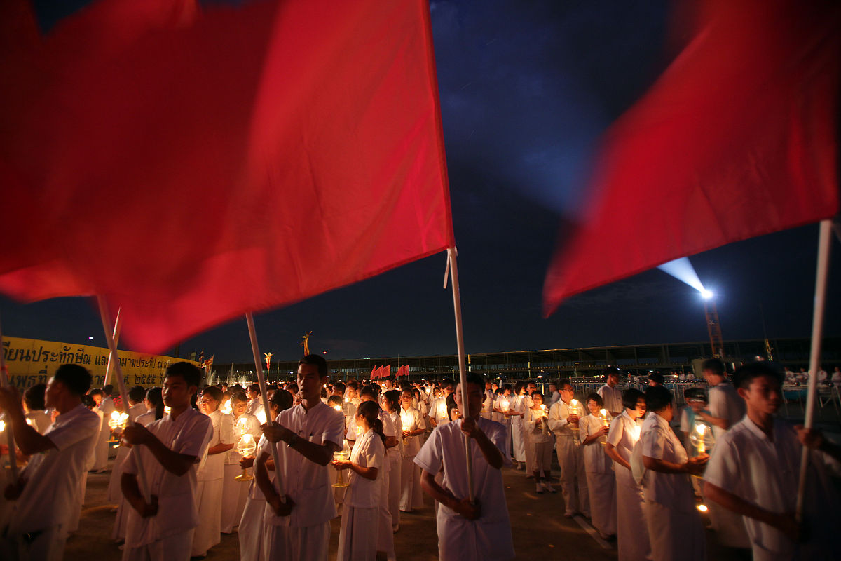 2012年3月7日,泰国巴吞他尼府,数千名僧侣坐在灯烛旁诵经,庆祝万佛节.