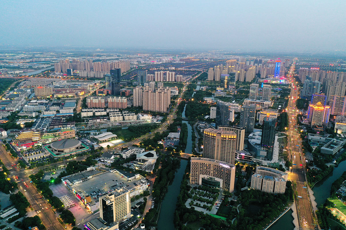 2020年5月19日傍晚,航拍苏州市吴江区,华灯初上,城市的霓虹与天光交相
