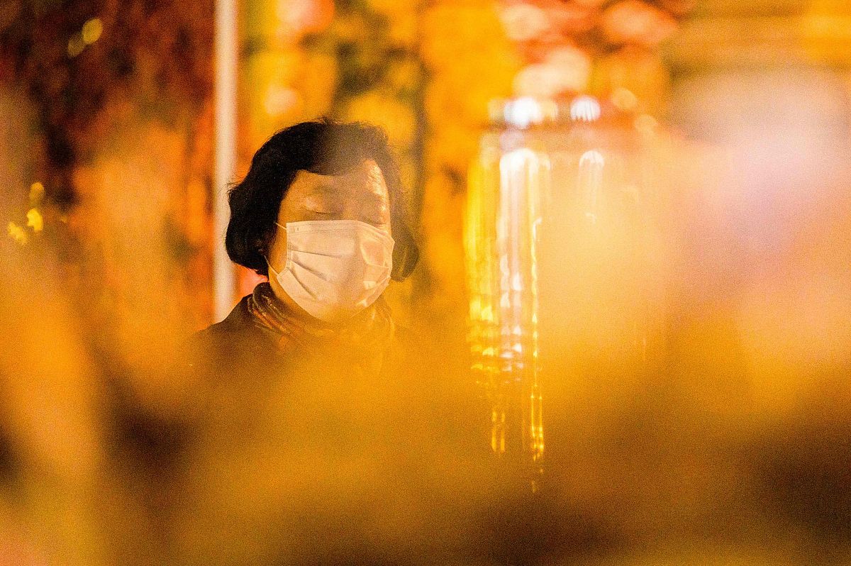 当地时间2021年11月17日,韩国首尔,考生家长在寺院外点燃蜡烛祈福.韩