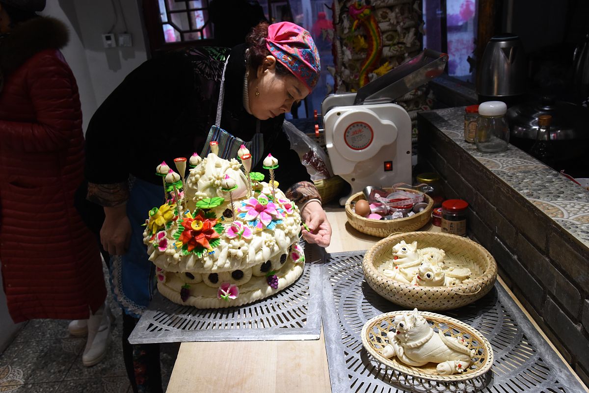 2019年12月01日,西安永兴坊,王利贞正在为客户制作长寿花馍.