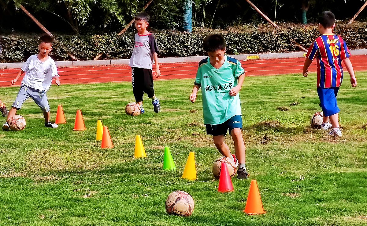 2021年9月2日,武汉关小学,小学生们在课后托管班上学踢足球.