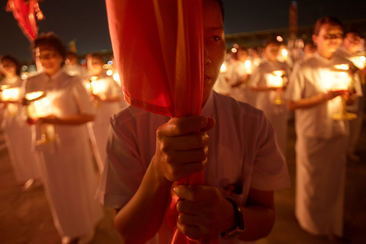 2012年3月7日,泰国巴吞他尼府,数千名僧侣坐在灯烛旁诵经,庆祝万佛节.