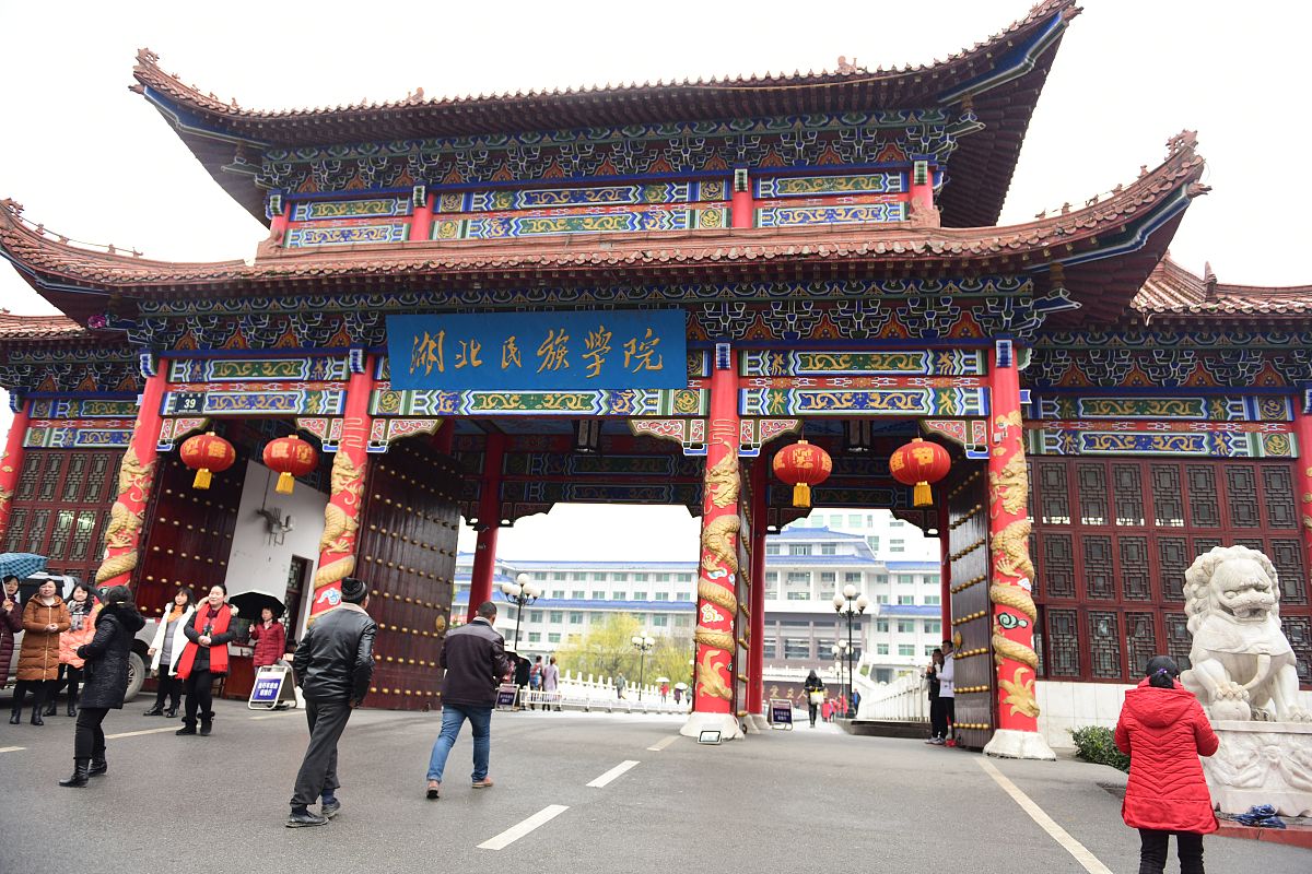 2018年12月27日,湖北恩施,市民,学生在湖北民族大学校门口留影,驻足,