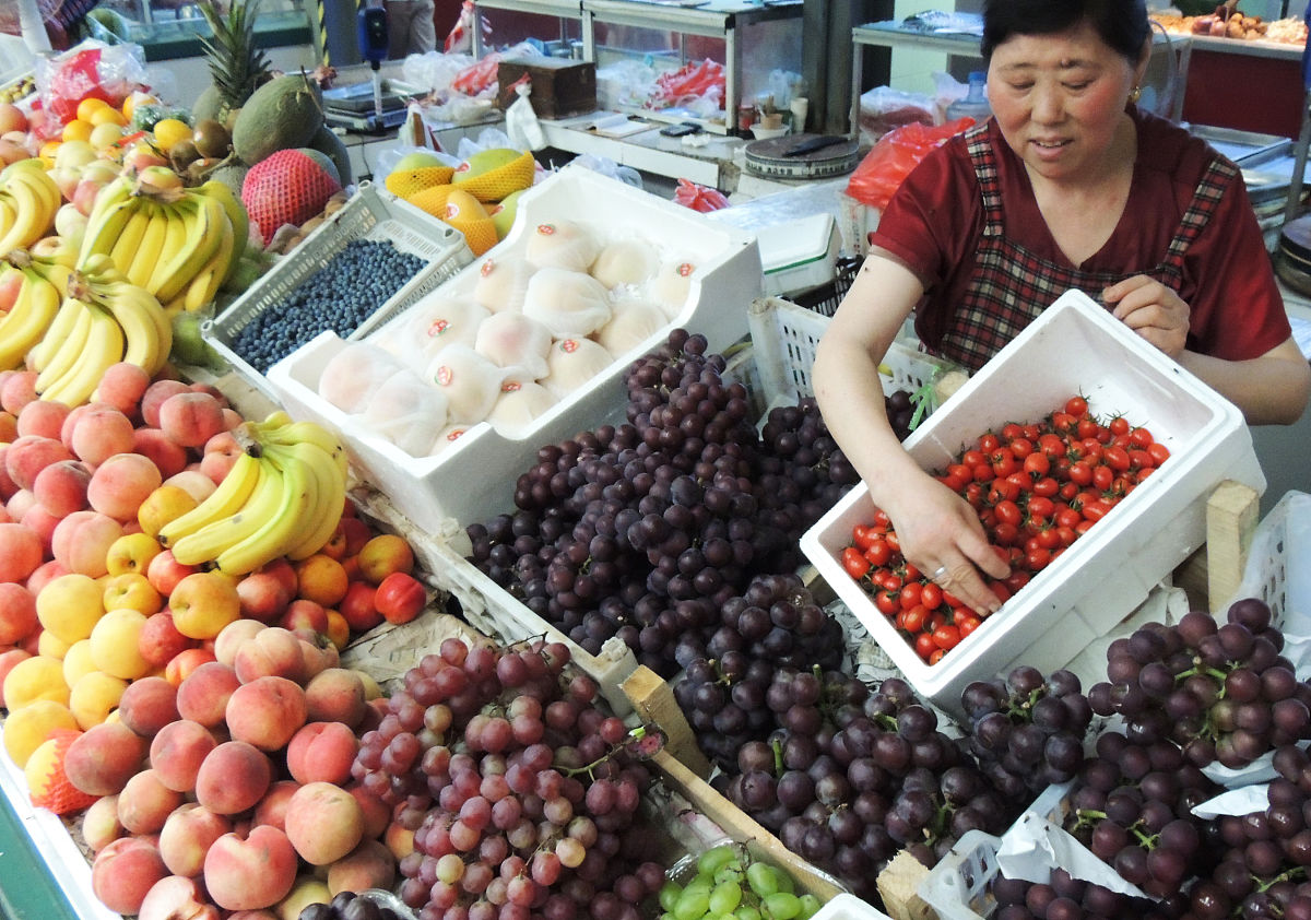2019年8月9日,江苏连云港市东部城区农贸市场,摊主在整理水果.