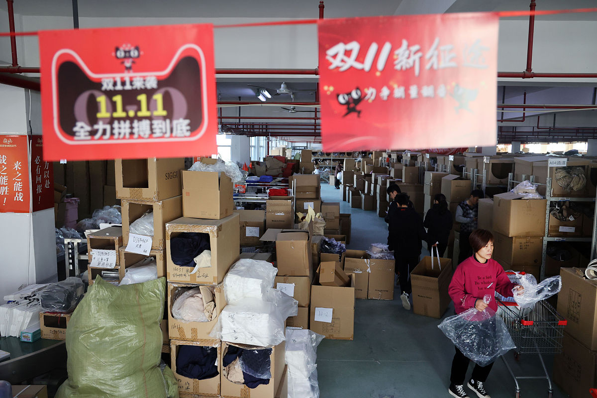 2021年11月11日,在江苏省南通市,电商公司的仓储人员在配货打包商品.