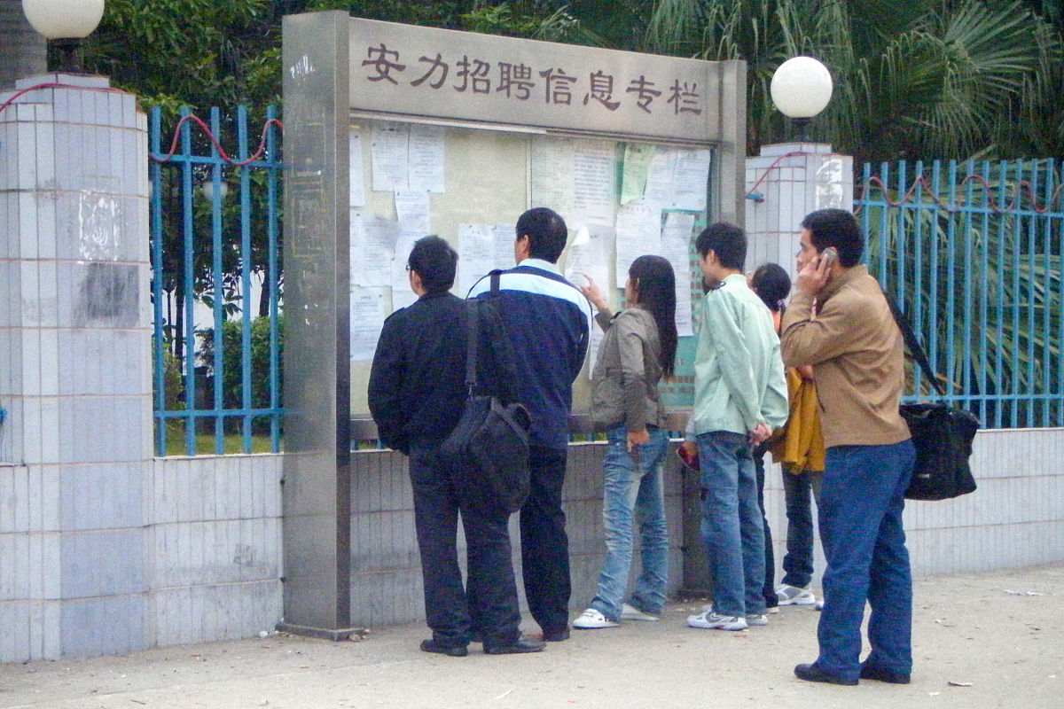 2009年12月13日,广东省东莞市,打工者查看招工广告.