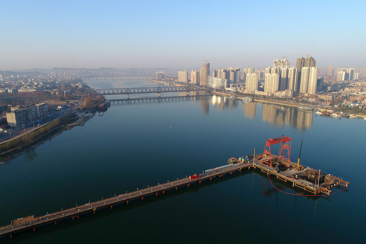 2017年12月19日,湖北省襄阳市,一群鸽子飞过正在建设中的庞公大桥施工
