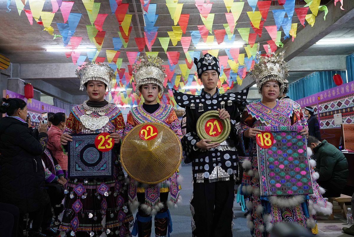 2022年1月2日,在广西融水苗族自治县香粉乡雨卜苗寨,三名苗妹拿着竹编