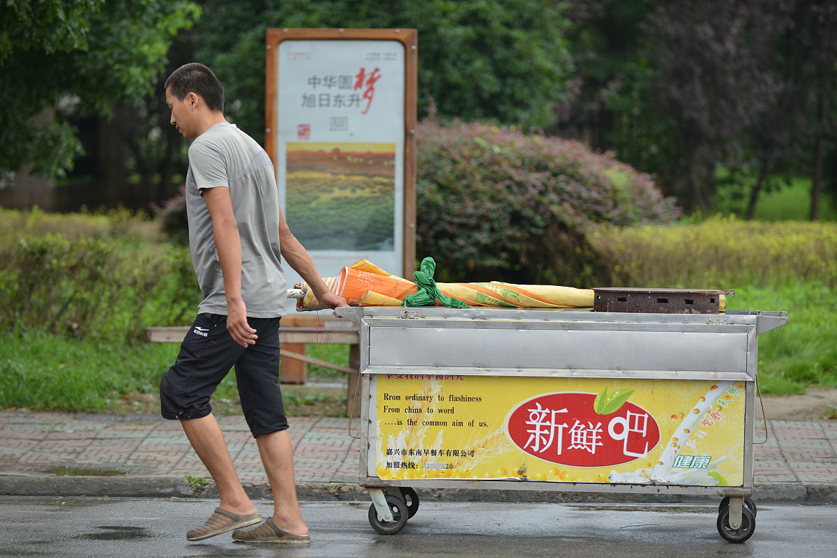 2014年7月25日,浙江嘉兴,摄影师拍摄街头摊贩夫妻的爱情故事.(夏绍权