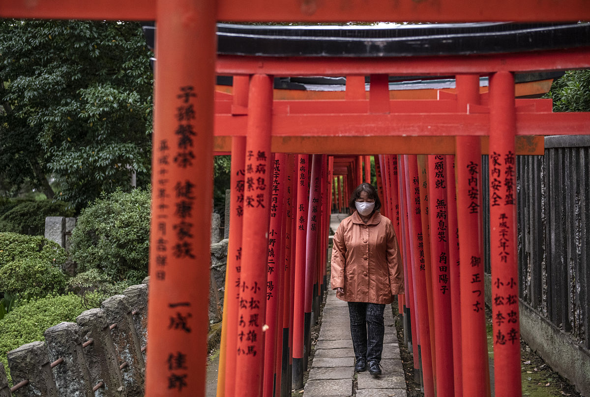 请描写一下一个老婆婆带着两个年轻人在神社参拜一个女巫的神像并带着他们去偏殿吃了一些东西就向山下走去