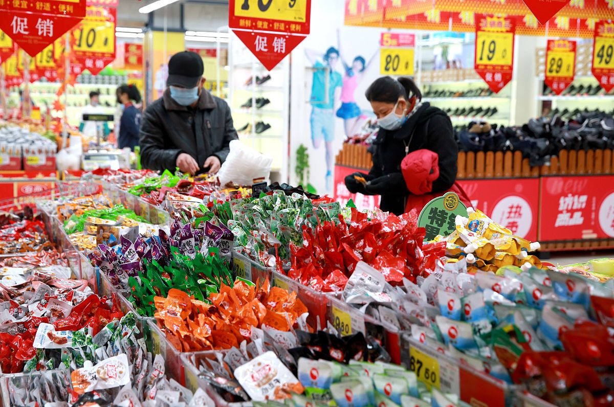 2021年1月29日,顾客在安徽安庆一家大型超市的年货大街上选购商品.