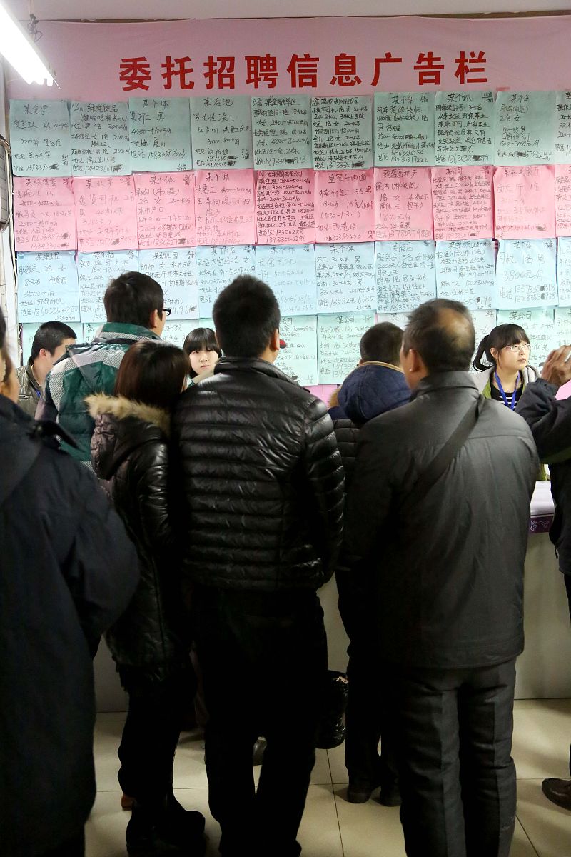 2014年2月8日,求职者观看招聘信息广告栏.