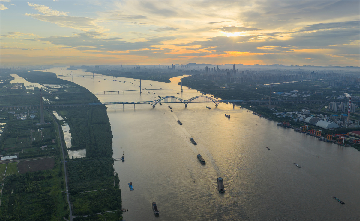 将以下内容意译翻译成英文： 武汉因水而兴。汉江口楚天潮阔。 江汉因长江、汉水在此交汇而得名天下。《明史》汉阳府记载：大江自巴陵县西北接洞庭之水流入府境至此与汉水会。