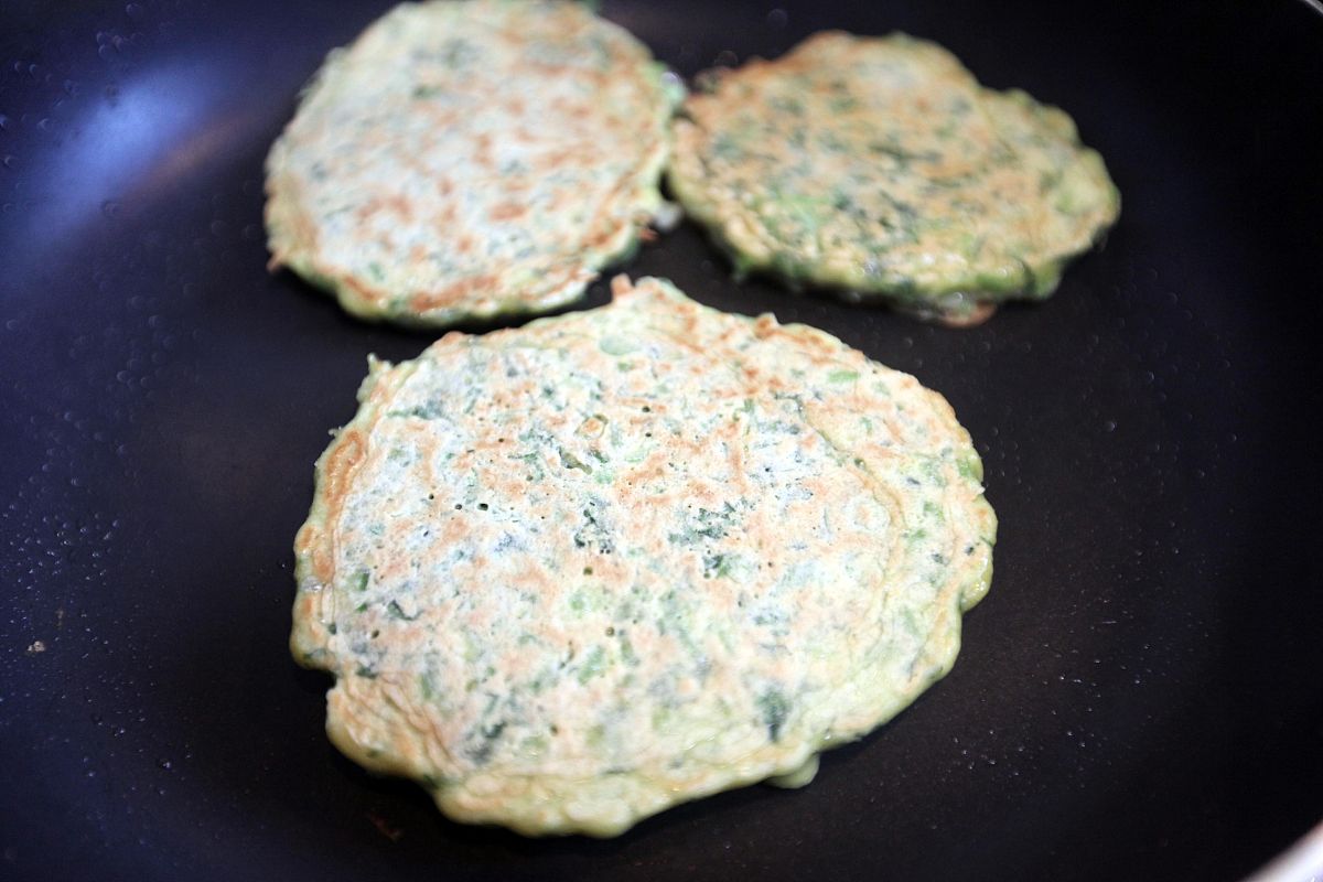 【茼蒿鸡蛋饼】的制作过程 等面饼底部定型之后,翻另一面煎,等到两面