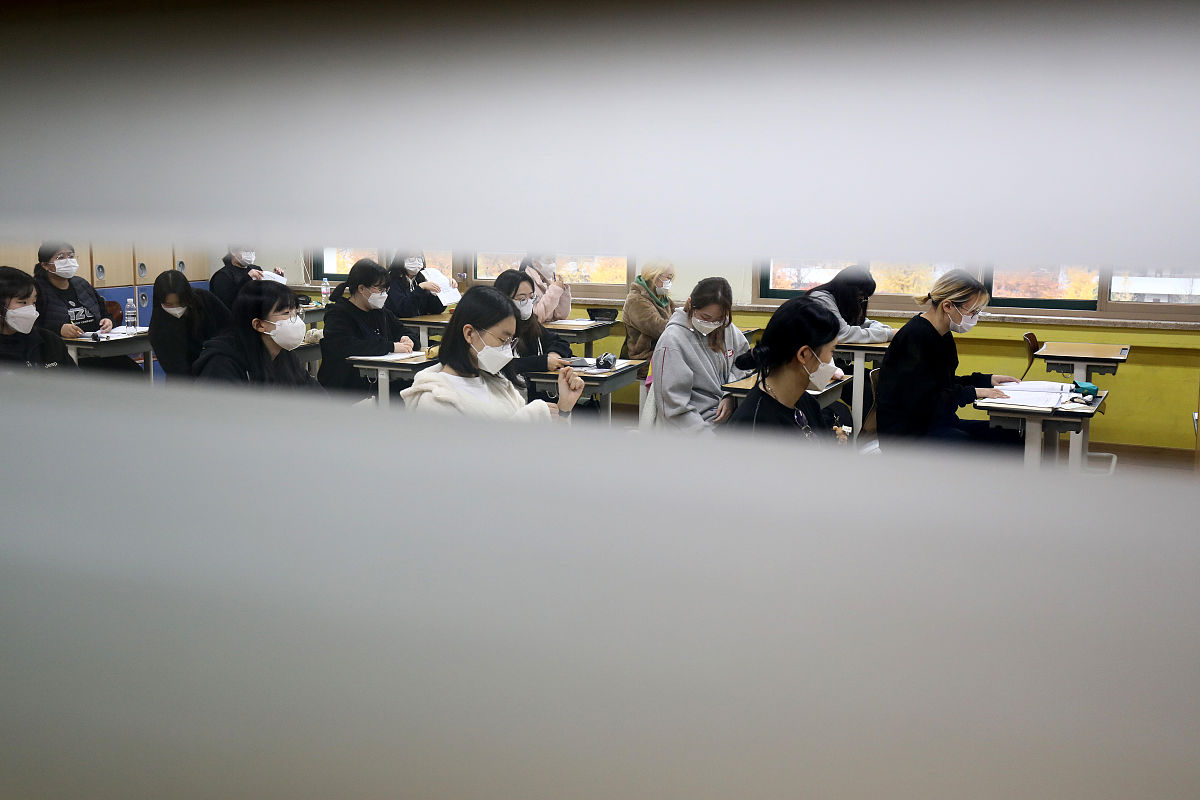 当地时间2021年11月18日,韩国首尔,考生们相继进入考场.韩国2022学年