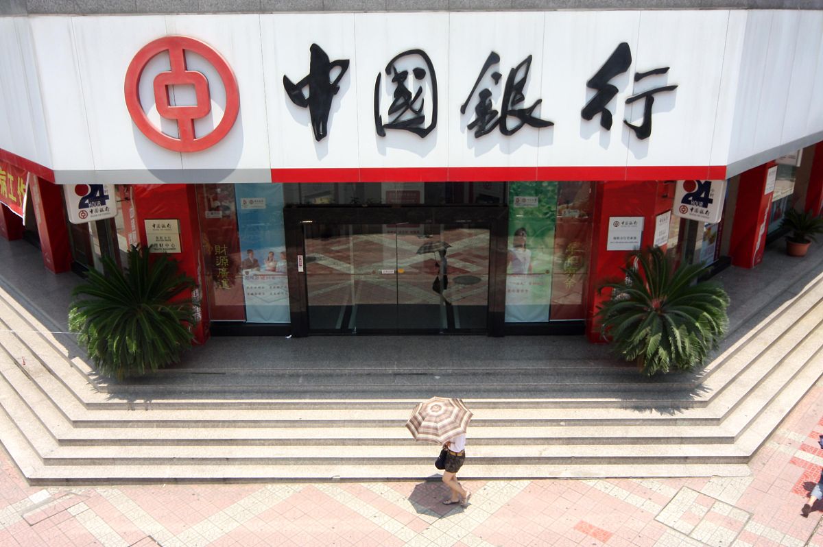2008年7月6日,四川绵阳,中国银行前行人打伞经过.