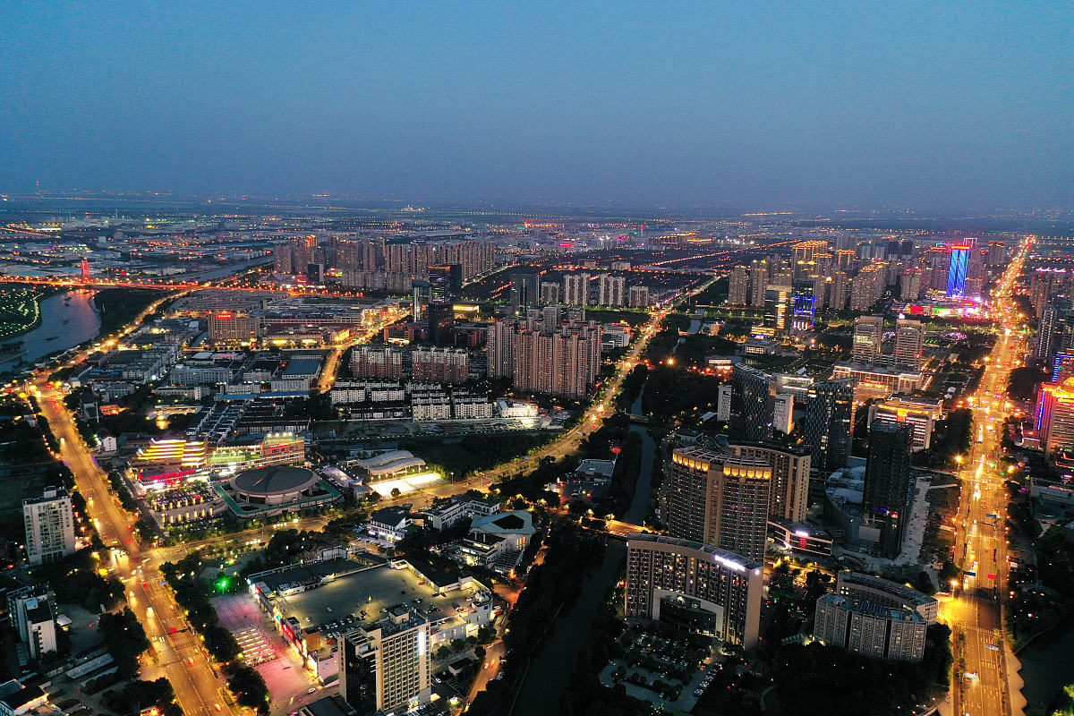 2020年5月19日傍晚,航拍苏州市吴江区,华灯初上,城市的霓虹与天光交相